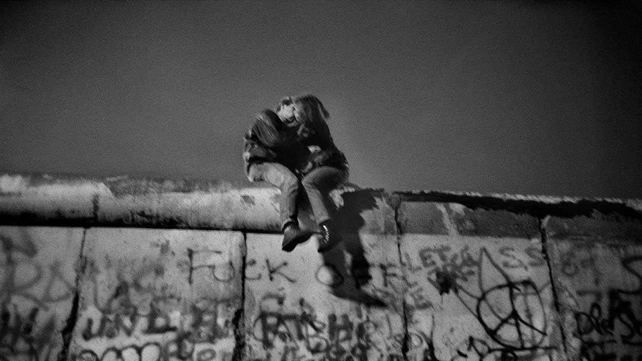 GERMANY. Berlin. On the wall, people celebrating New Year's Eve. Near the Brandenburg Gate, after the fall of the wall in November of 1989. Sunday 31th December, 1989 (around midnight).